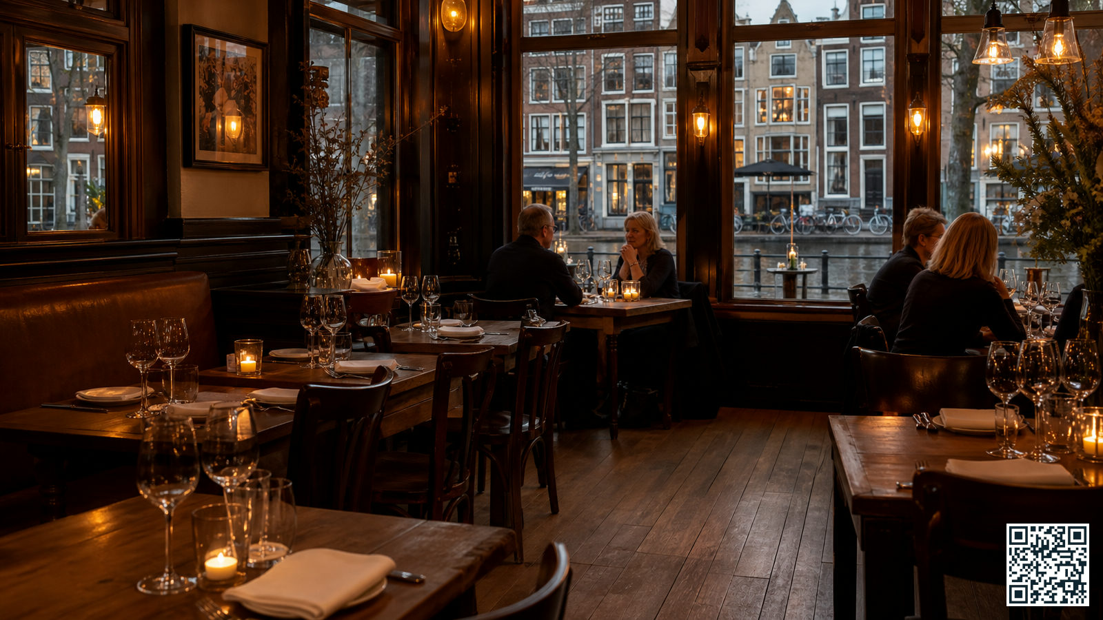 Gezellig restaurant bij Amsterdam Centraal dat ook op maandag open is, met warm verlichte tafels en uitzicht op een Amsterdamse gracht